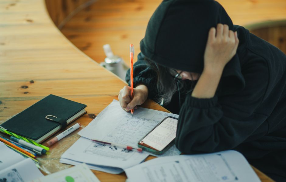 楼下电钻响到第三轮时，我趴在窗台上看见隔壁单元的老周搬了把藤椅，坐到小区花园的梧桐树底下。他戴着顶旧草帽，手里攥着半导体，午睡被吵得泡了汤，索性出来躲清静。几个放学的小孩经过，书包往石桌上一撂，掏出作业本开始写。老周眯着眼看了一会儿，忽然招手叫住一个男孩，问他数学题里那个圆圈加三角到底得几。男孩挠头说不会，老周便拿过铅笔，在草稿纸背面画起图来。